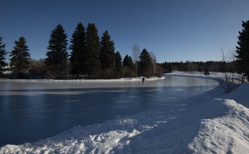 A person skating on Hawrelak Lake ice.